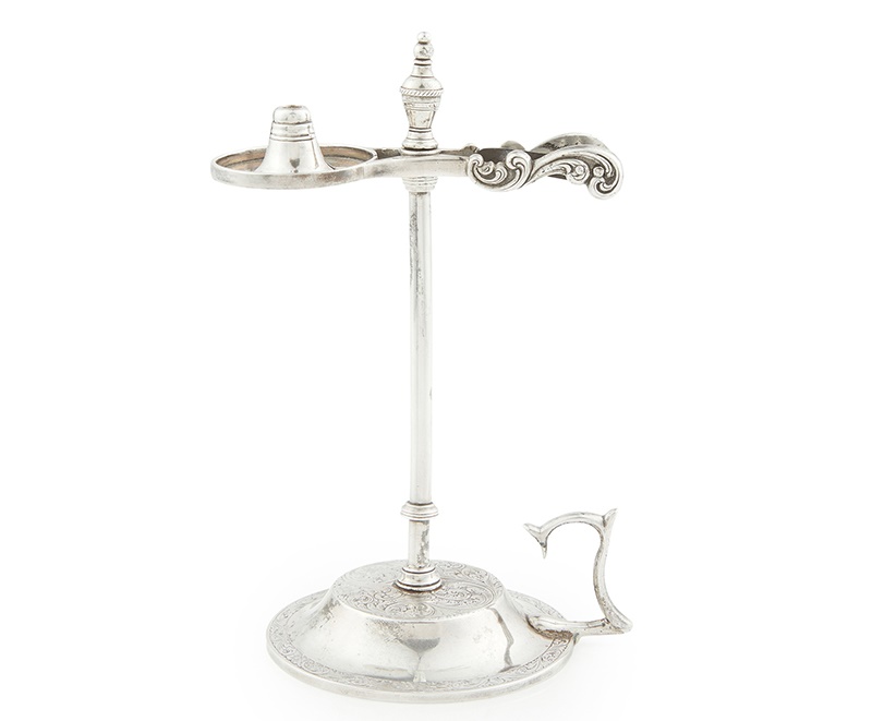 Lot 516 | Cupar- A Scottish provincial wax jack David Duncan (of Cupar), part marked circa 1840, the simple stem with clip attachment to top with scissor action, raised on a domed base with engraved foliate scroll and cast single handle Height: 16cm, weight: 4.6oz | £500 - £800 + fees
